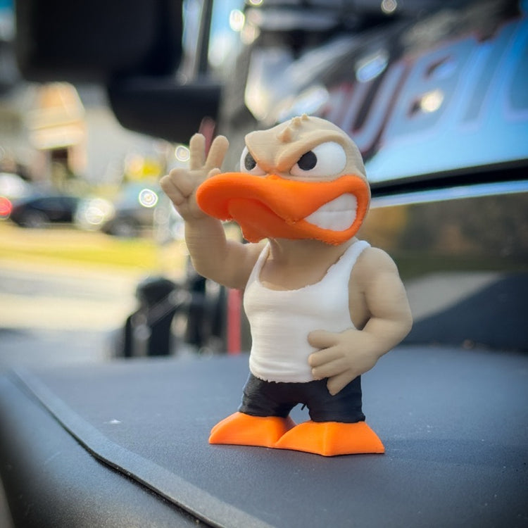 The FirstWarrior Tough Guy Duck is a small PLA figurine wearing a white tank top and black shorts, flashing a peace sign on your car dashboard. This fun accessory adds personality to any ride.