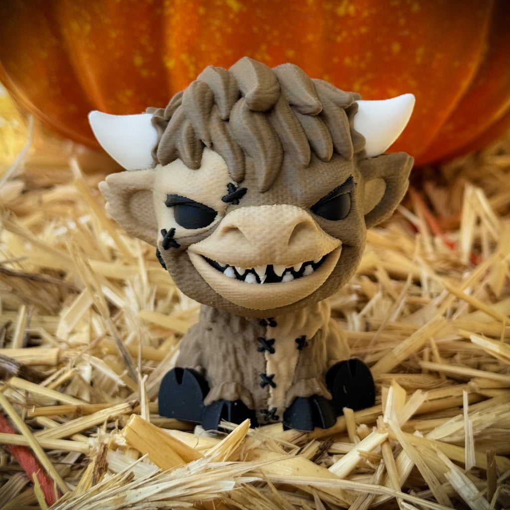 Patches Baby Highland by FirstWarrior is a small, brown, horned Highland Cow collectible with black stitches and a mischievous grin, sitting on straw in front of a pumpkin—perfect as a PLA plastic figurine desk ornament.