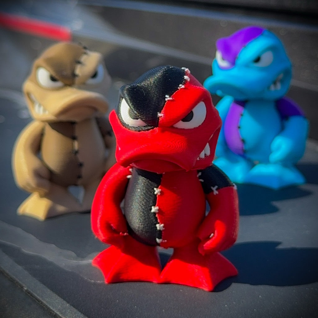 Three colorful figurines on a reflective surface